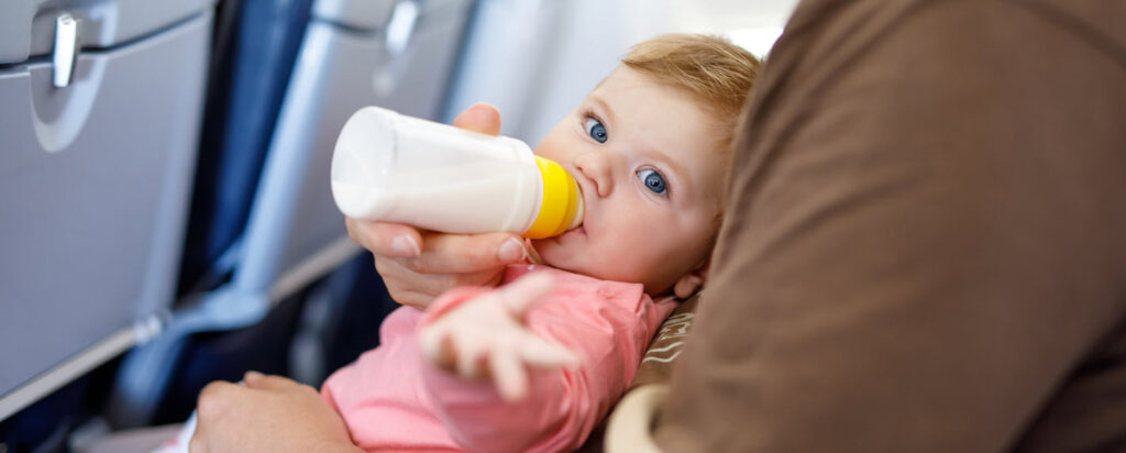 tips for flying with a baby - baby with bottle