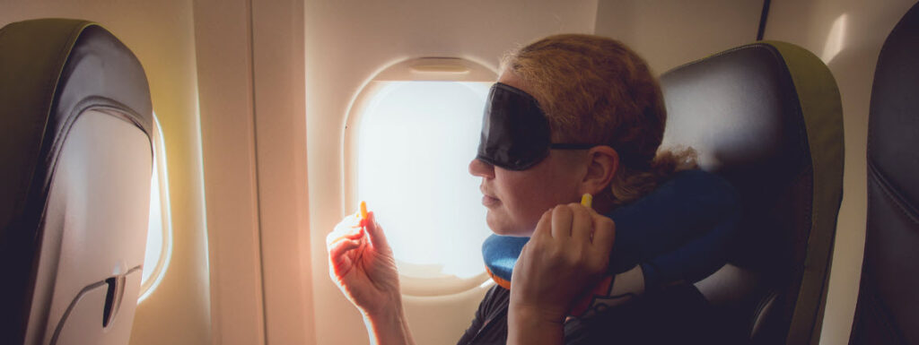 eye masks for travel - girl with eye mask on plane